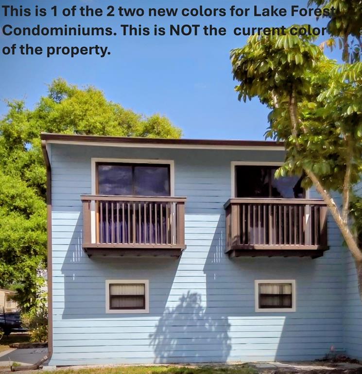 The exterior of a two-story building features light blue siding and two dark brown balconies — 6420 92ND PLACE UNIT 1202, PINELLAS PARK, FL