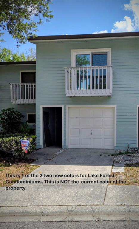 A two-story building exterior features light blue horizontal siding, a white garage door, and balconies — 6420 92ND PLACE UNIT 1202, PINELLAS PARK, FL