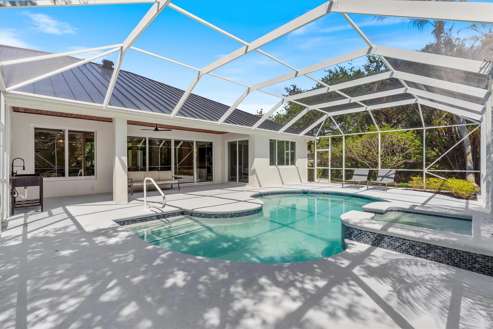 A screened-in patio features a swimming pool, a hot tub, and an outdoor sink area — 19029 SE Kokomo Lane, Jupiter FL 33458, JUPITER, FL