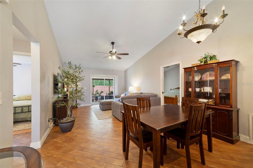 A dining area with a wooden table and hutch opens into a living room — 9478 BRACKIN STREET, ORLANDO, FL