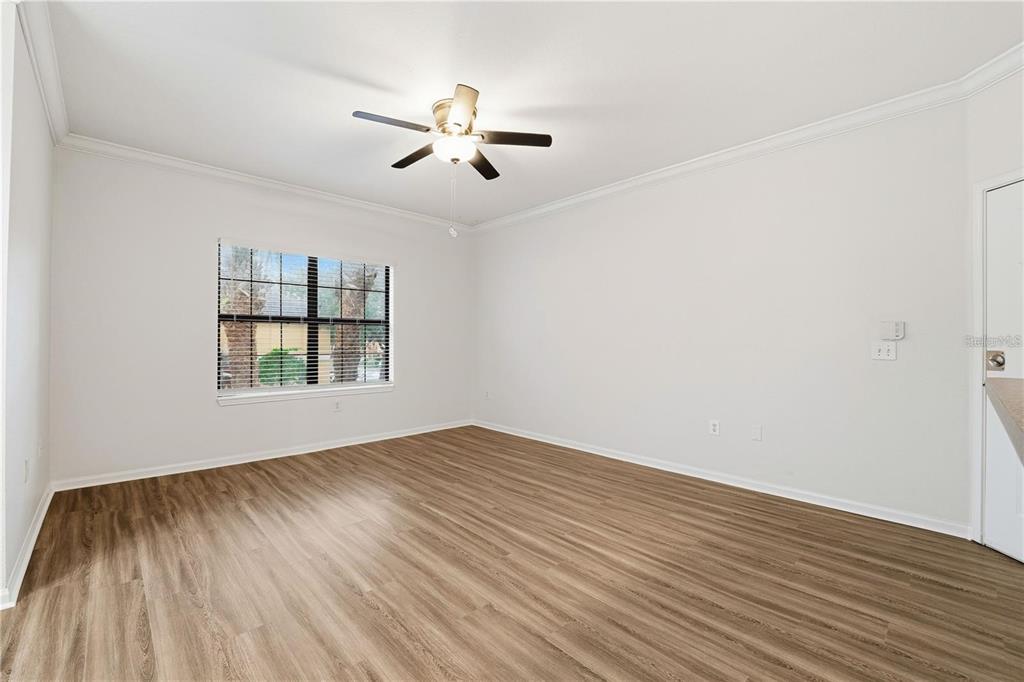 An empty room with light-colored walls, wood-look flooring, a ceiling fan, and a window — 2249 PORTOFINO PLACE UNIT 22-2217, PALM HARBOR, FL