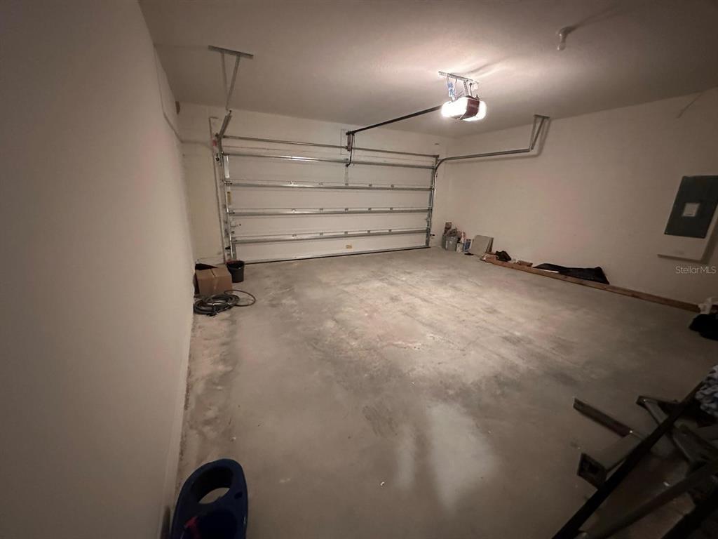 An empty two-car garage with a concrete floor, white walls, and a sectional door — 975 BROOKLET DRIVE, DAVENPORT, FL