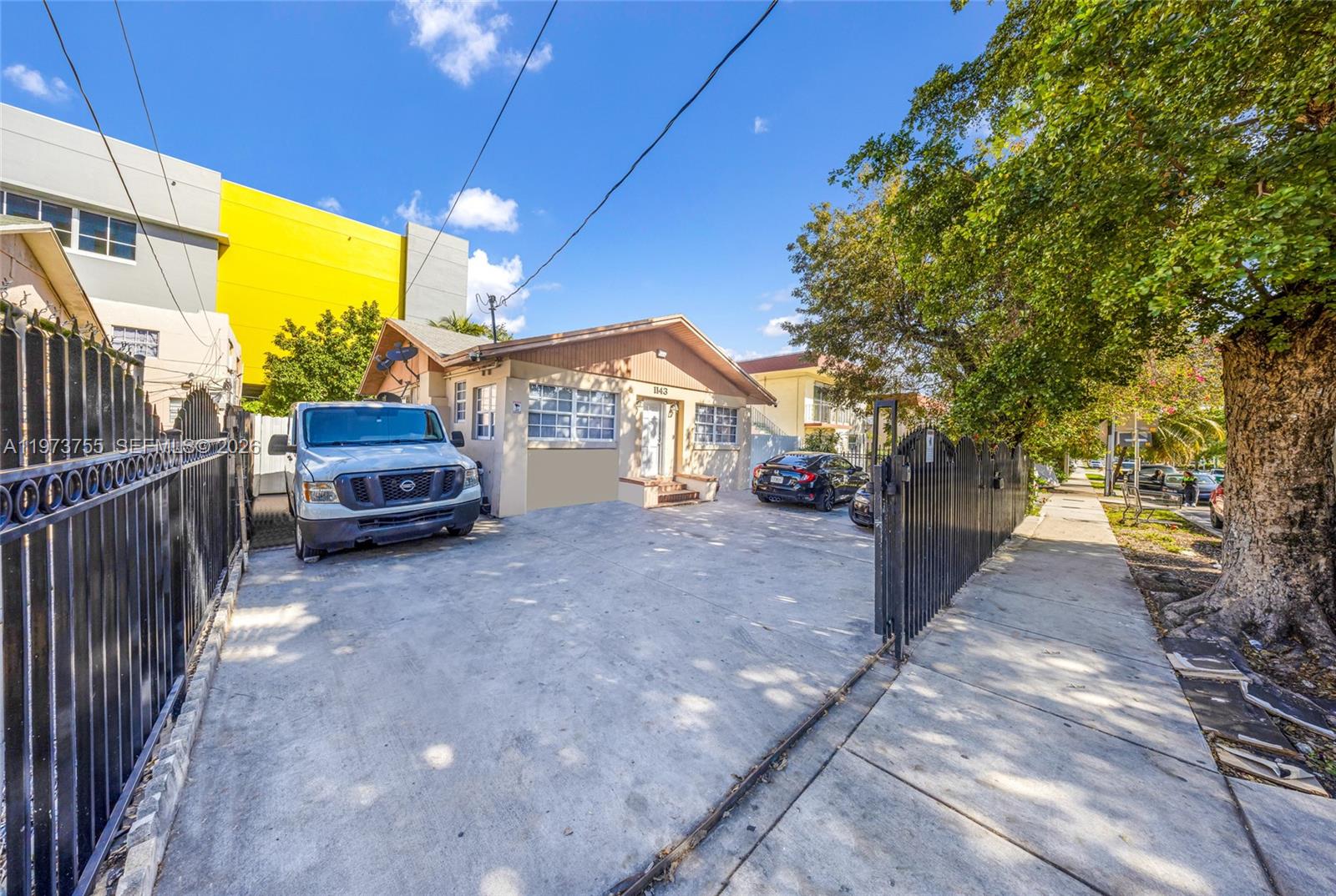 A single-story house with a concrete driveway, a white truck, and a black metal fence — 1143 NW 6th St, Miami FL 33136, MIAMI, FL