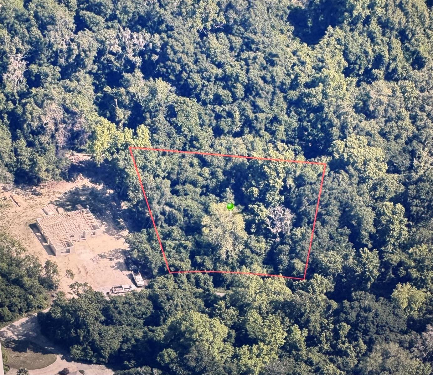 An aerial view shows a wooded lot outlined in red next to a house under construction — 6761 E Dogwood Hammock Drive, Inverness FL 34453, INVERNESS, FL
