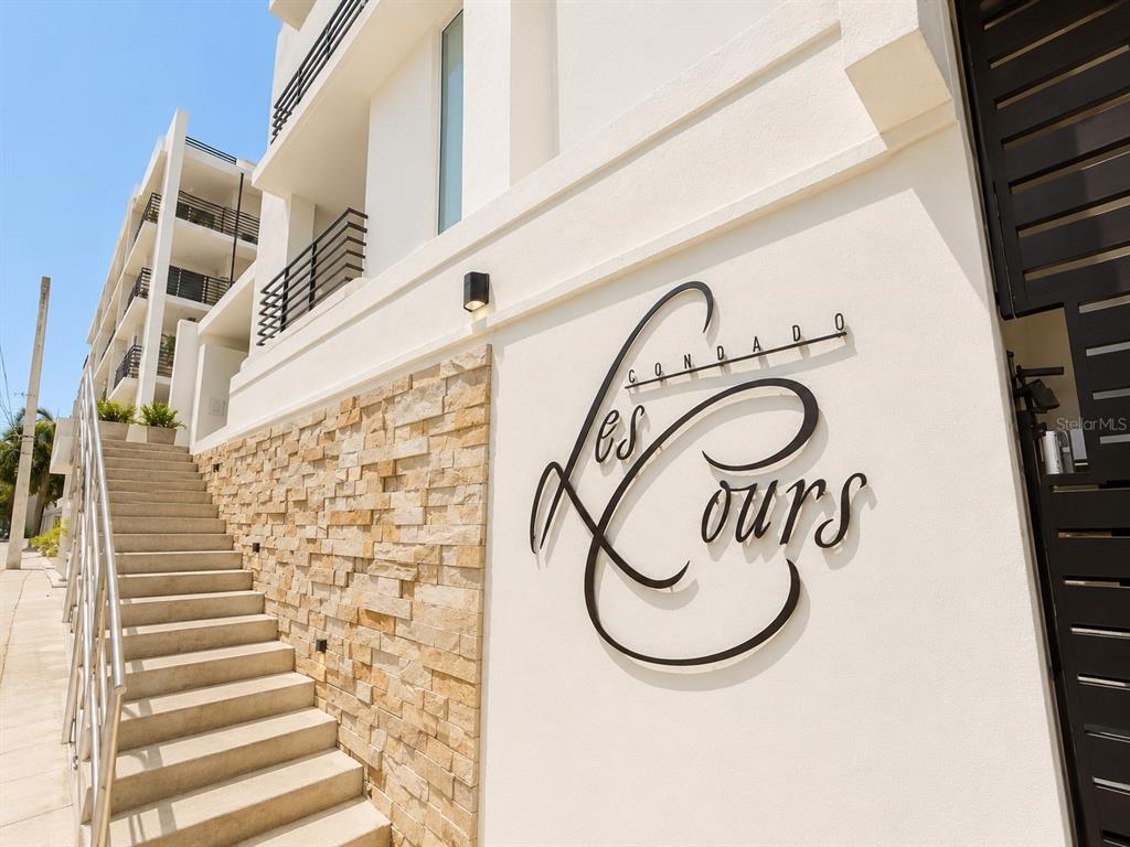 A modern building exterior features a stone accent wall, a staircase, and signage — 1554 CALLE LÓPEZ LANDRÓN apt #301, SAN JUAN, PR