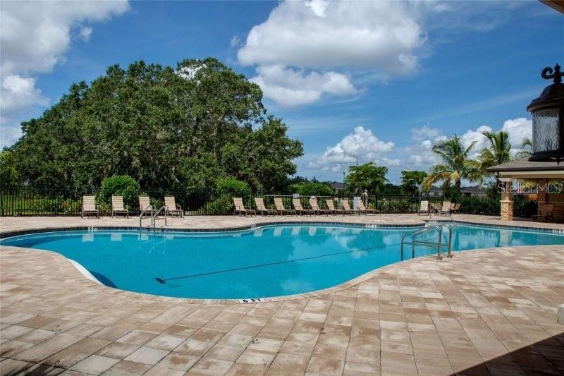 A swimming pool with lounge chairs on a paved deck under a blue sky — 7104 W LENOX CIRCLE, PUNTA GORDA, FL