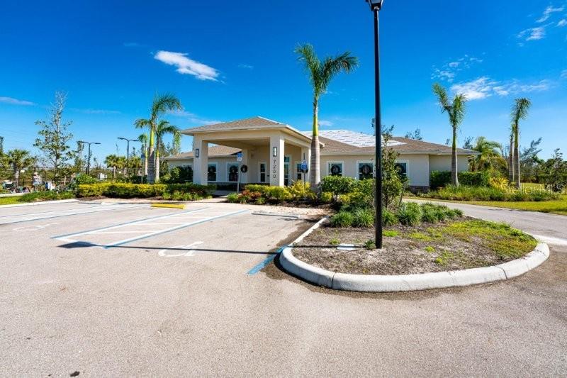 A single-story building with a covered entrance and palm trees in a parking lot — 7104 W LENOX CIRCLE, PUNTA GORDA, FL