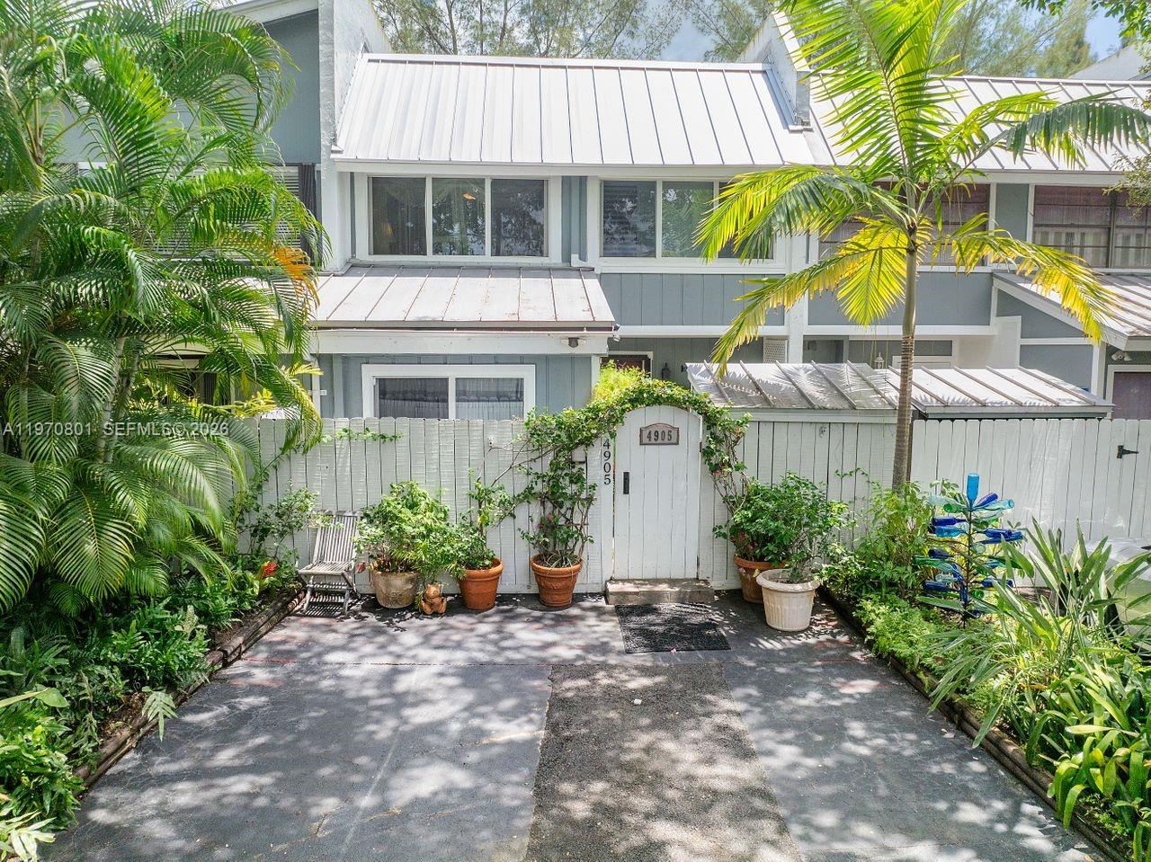 A paved driveway leads to a white wooden gate and fence in front of a townhouse — 4905 SW 71st Pl, Miami FL 33155, MIAMI, FL