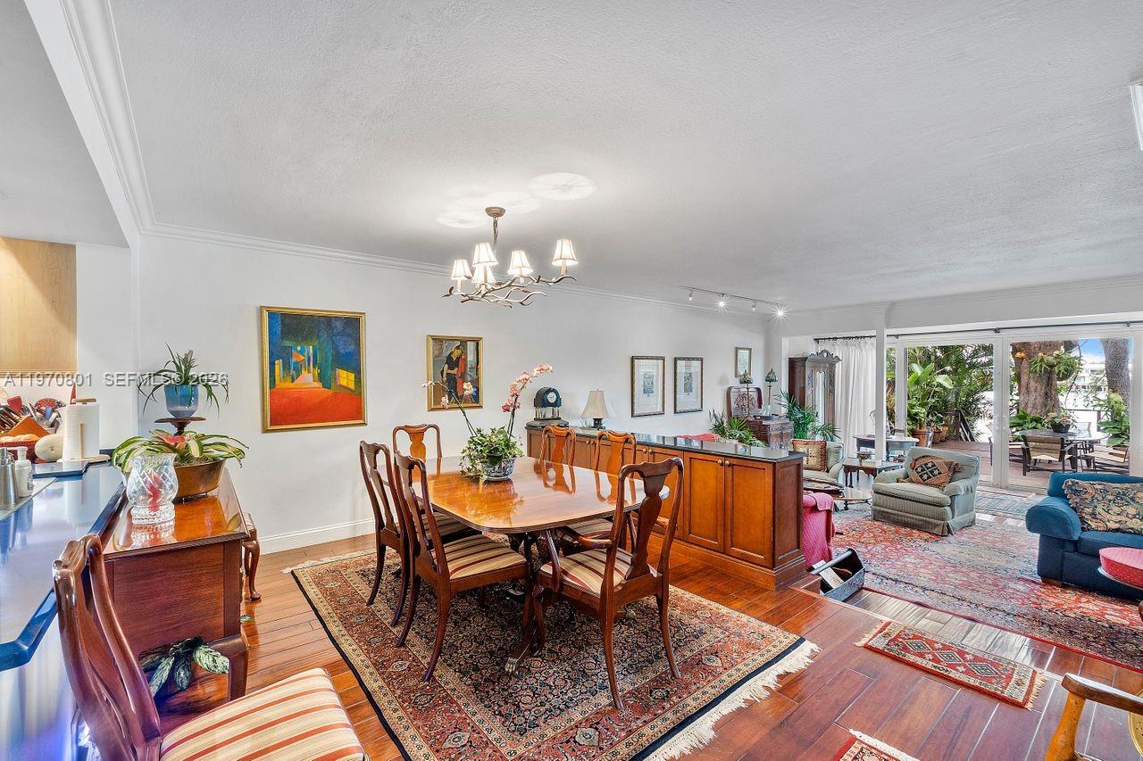 A dining area with a wooden table and chairs sits adjacent to a living room — 4905 SW 71st Pl, Miami FL 33155, MIAMI, FL