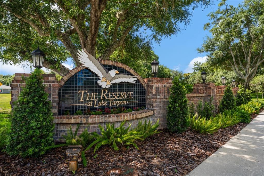 A brick entrance sign for The Reserve at Lake Tarpon features a bald eagle emblem — 3909 TARIAN COURT, PALM HARBOR, FL