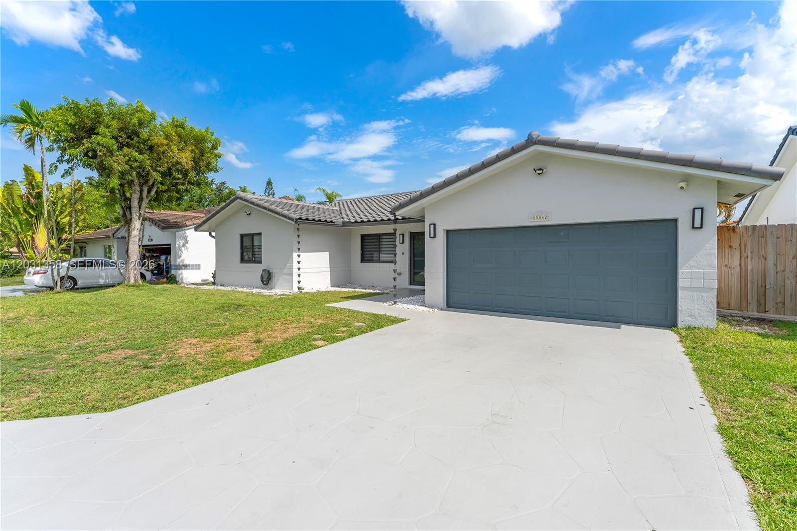 A single-story house with a gray garage door, white exterior, and a tiled roof — 15842 SW 105th St, Miami FL 33196, MIAMI, FL