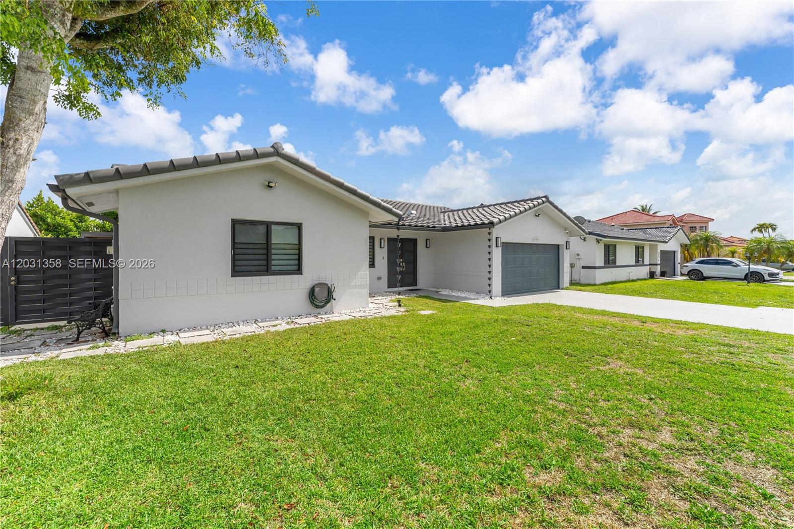 A single-story house with a gray tile roof, white exterior, and a front-facing garage — 15842 SW 105th St, Miami FL 33196, MIAMI, FL