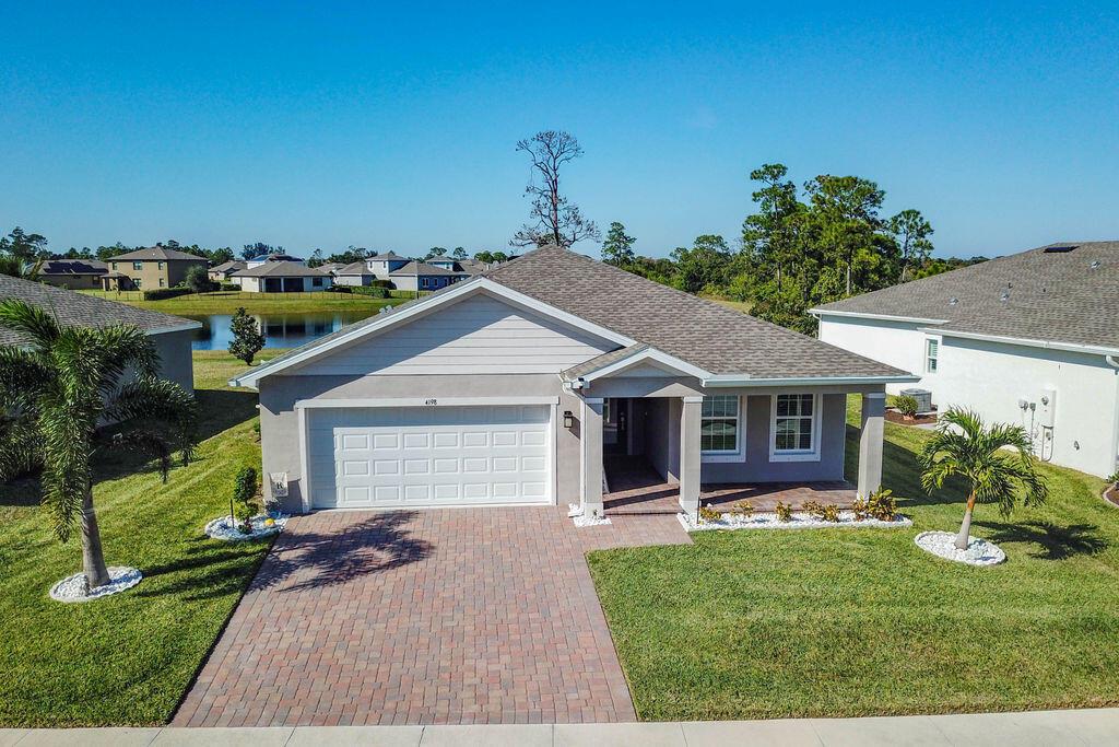 An aerial view of a single-story suburban house with a paved driveway and front porch — 4198 Keeson Circle, Vero Beach FL 32967, VERO BEACH, FL