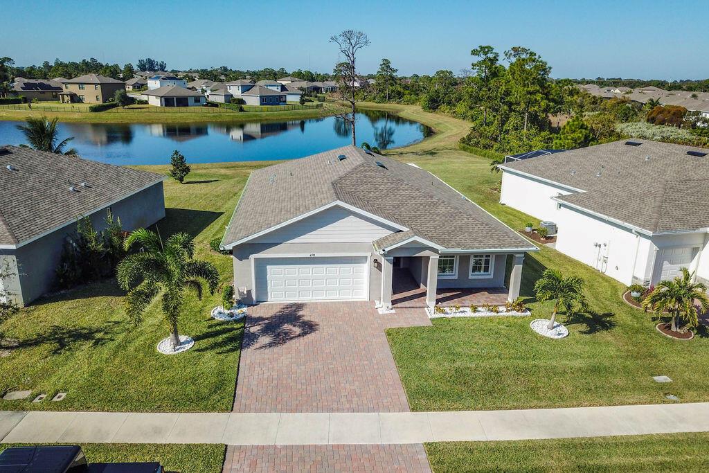 An aerial view of a single-story suburban house with a paved driveway and a pond — 4198 Keeson Circle, Vero Beach FL 32967, VERO BEACH, FL