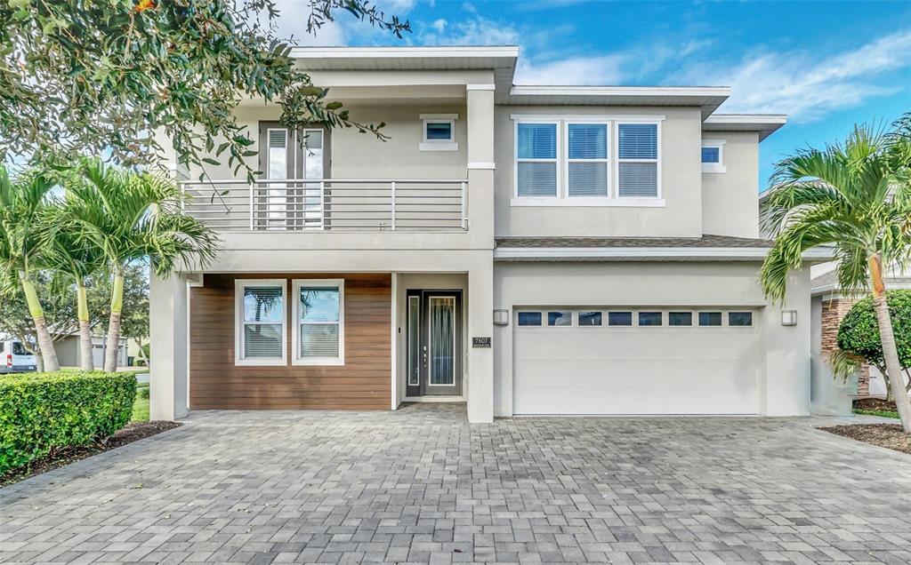 A two-story house with a paved driveway, a balcony, and a two-car garage — 7607 MACKINAW LANE, KISSIMMEE, FL