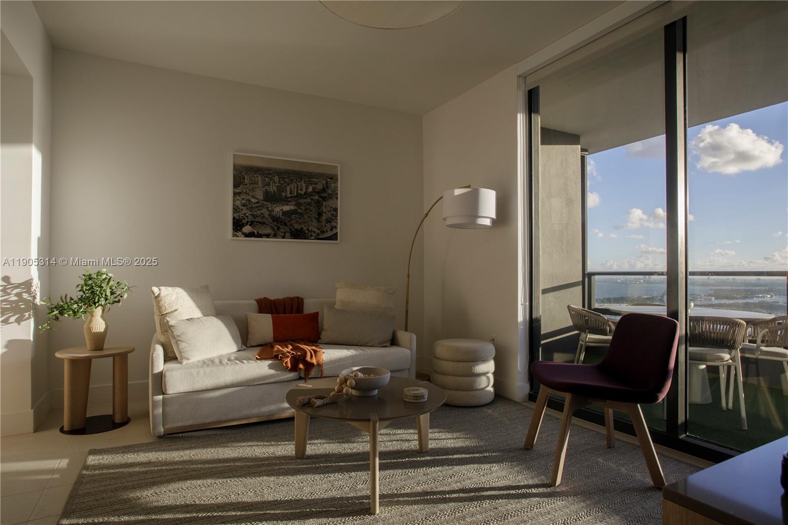 A modern living room features a sofa, coffee table, and floor-to-ceiling windows with balcony access — 159 NE 6th St # 2816, Miami FL 33132, MIAMI, FL