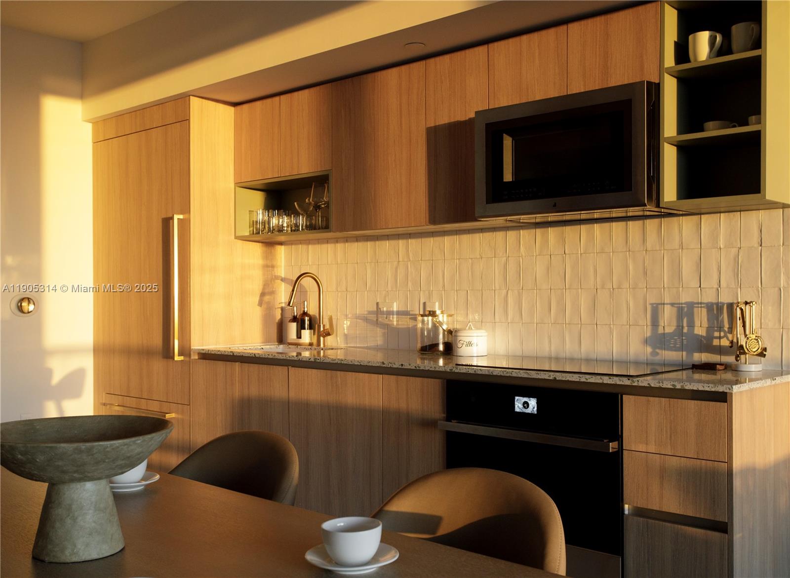 A modern kitchen features light wood cabinetry, a tiled backsplash, and integrated stainless steel appliances — 159 NE 6th St # 2816, Miami FL 33132, MIAMI, FL