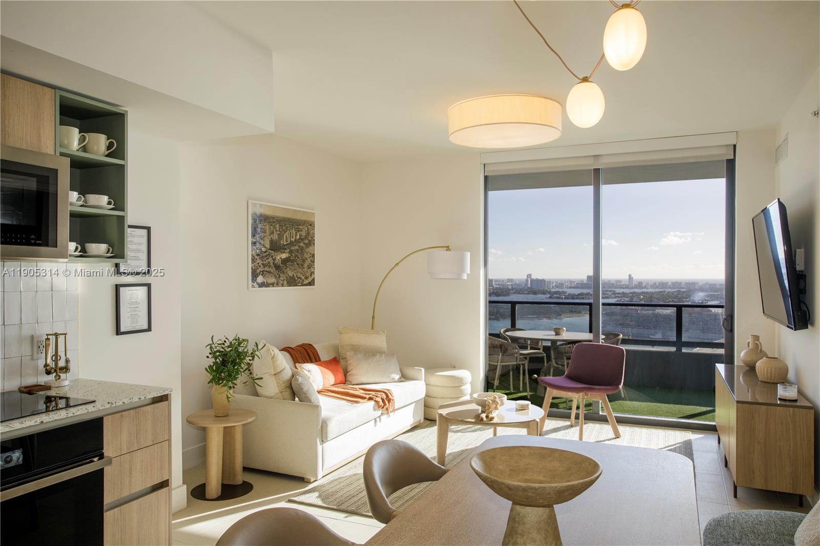 A modern apartment living area features a kitchen, sofa, dining table, and a balcony view — 159 NE 6th St # 2816, Miami FL 33132, MIAMI, FL