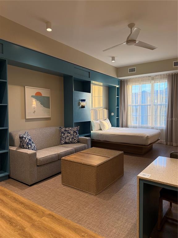 A studio apartment features a sofa, a bed, and built-in blue shelving units — 3151 SUNSET WALK DR UNIT 516, KISSIMMEE, FL