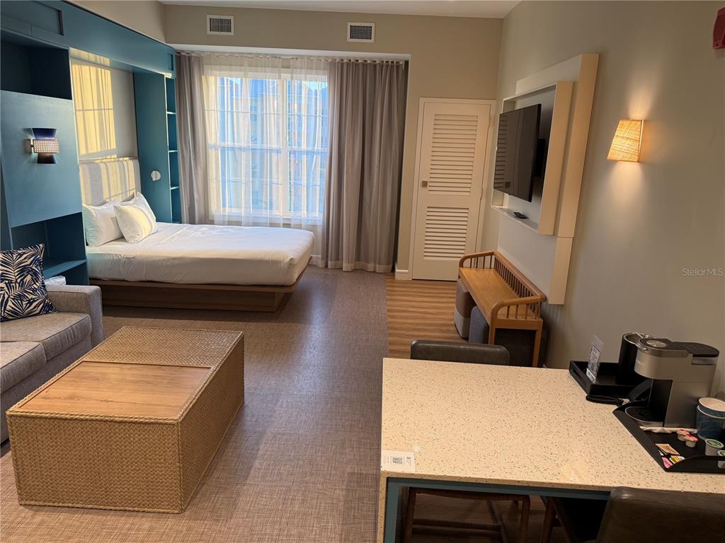 A hotel room features a bed, a sofa, a coffee table, and a small kitchenette — 3151 SUNSET WALK DR UNIT 516, KISSIMMEE, FL