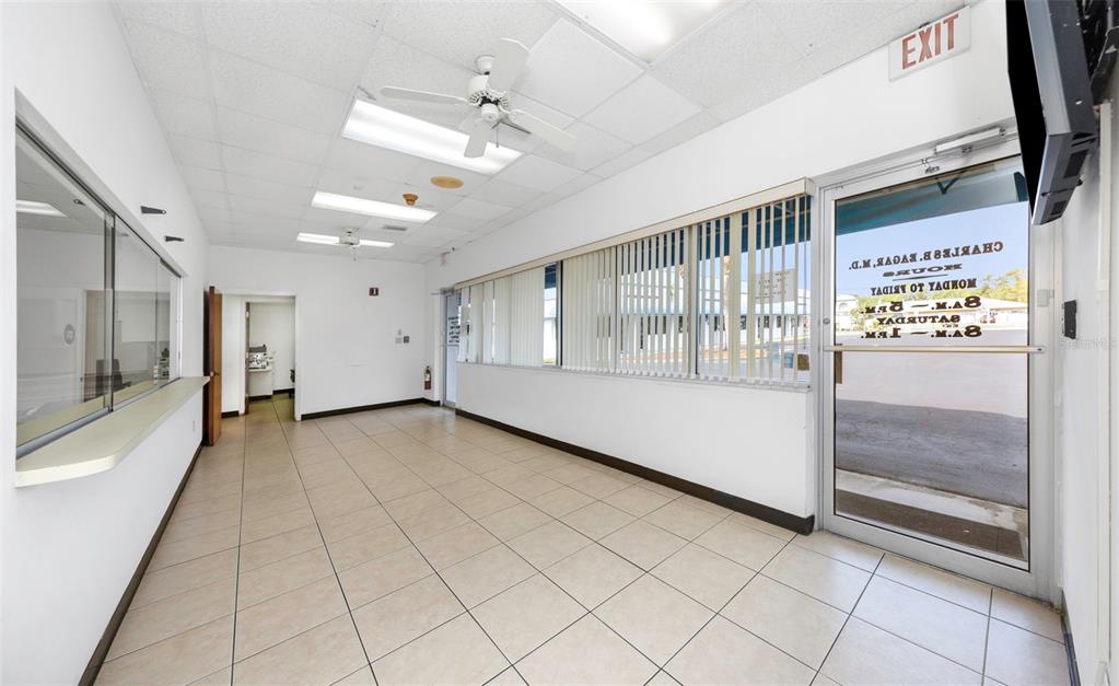 An empty commercial office space features white walls, tiled flooring, a ceiling fan, and a glass entrance — 655 N INDIANA AVENUE, ENGLEWOOD, FL