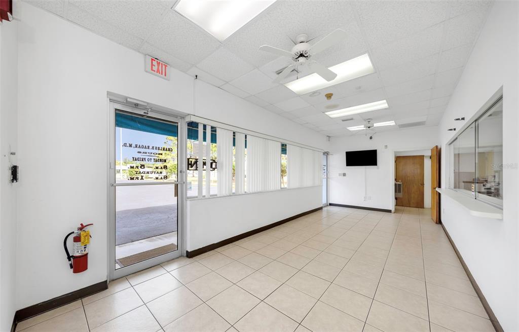 An empty commercial office space with white walls, tiled floors, and a glass entrance door — 655 N INDIANA AVENUE, ENGLEWOOD, FL