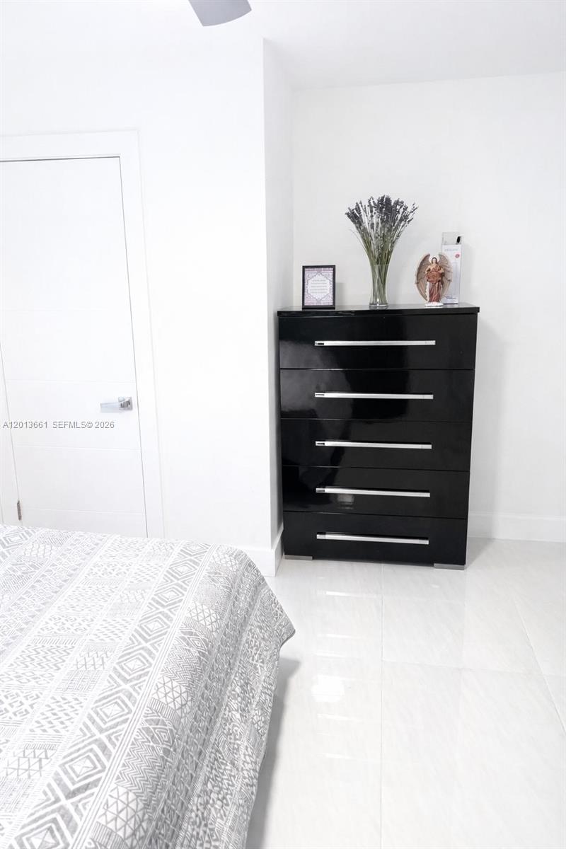A bedroom features a black dresser with silver handles and a patterned bedspread — 1001 NE 10th St # 2, Hallandale Beach FL 33009, HALLANDALE BEACH, FL