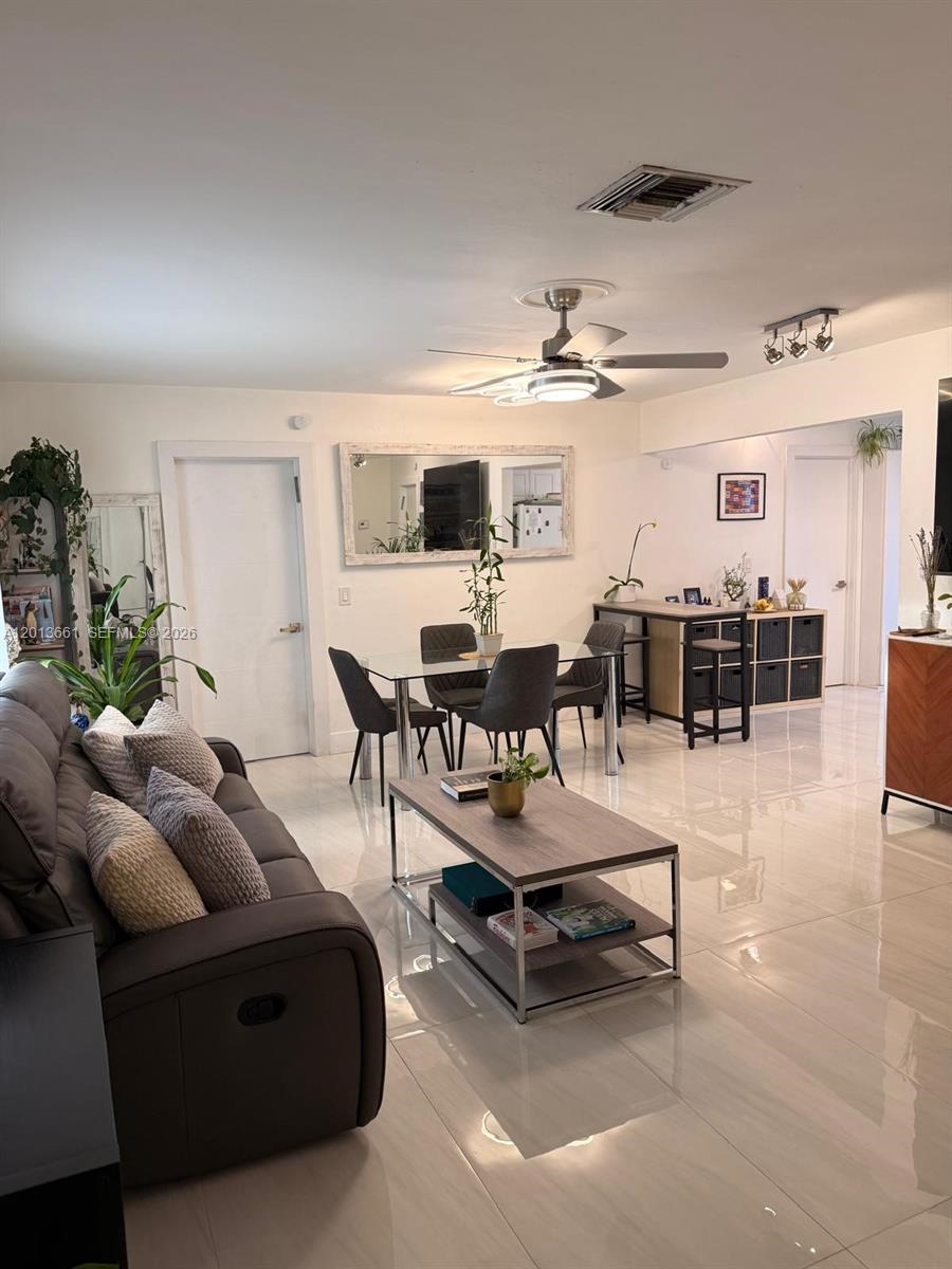 A living and dining area features white tile floors, a glass dining table, and furniture — 1001 NE 10th St # 2, Hallandale Beach FL 33009, HALLANDALE BEACH, FL