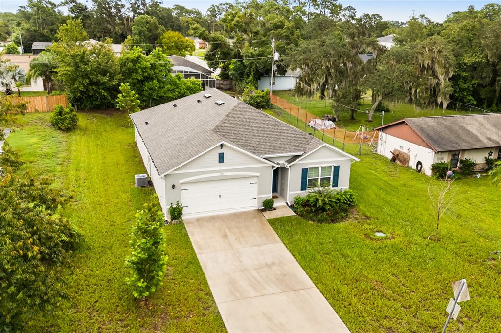 An aerial view of a single-story house with a white garage and a concrete driveway — 1340 BLADON AVENUE, DELTONA, FL