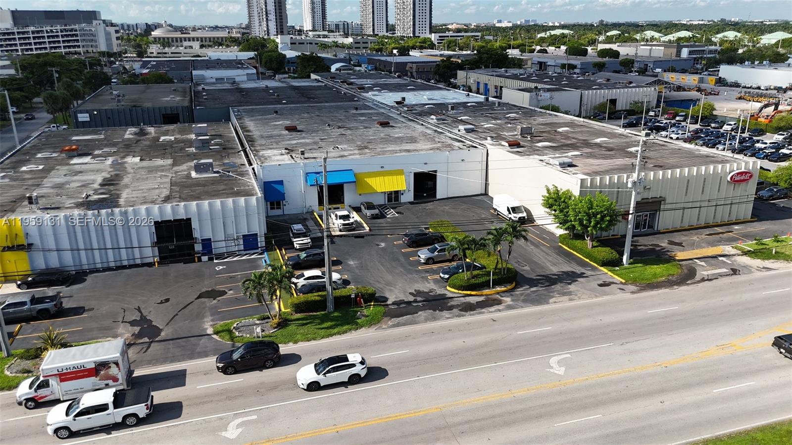 An aerial view shows a commercial warehouse building with a parking lot and adjacent road — 8420 NW 58th St, Doral FL 33166, DORAL, FL