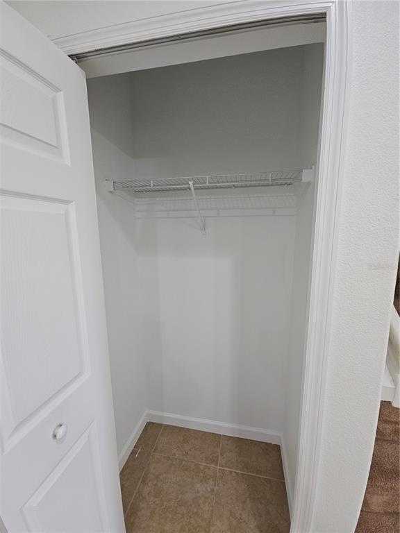 A small closet with a white wire shelf and light-colored tile flooring — 1899 PORTOFINO MEADOWS BOULEVARD, ORLANDO, FL