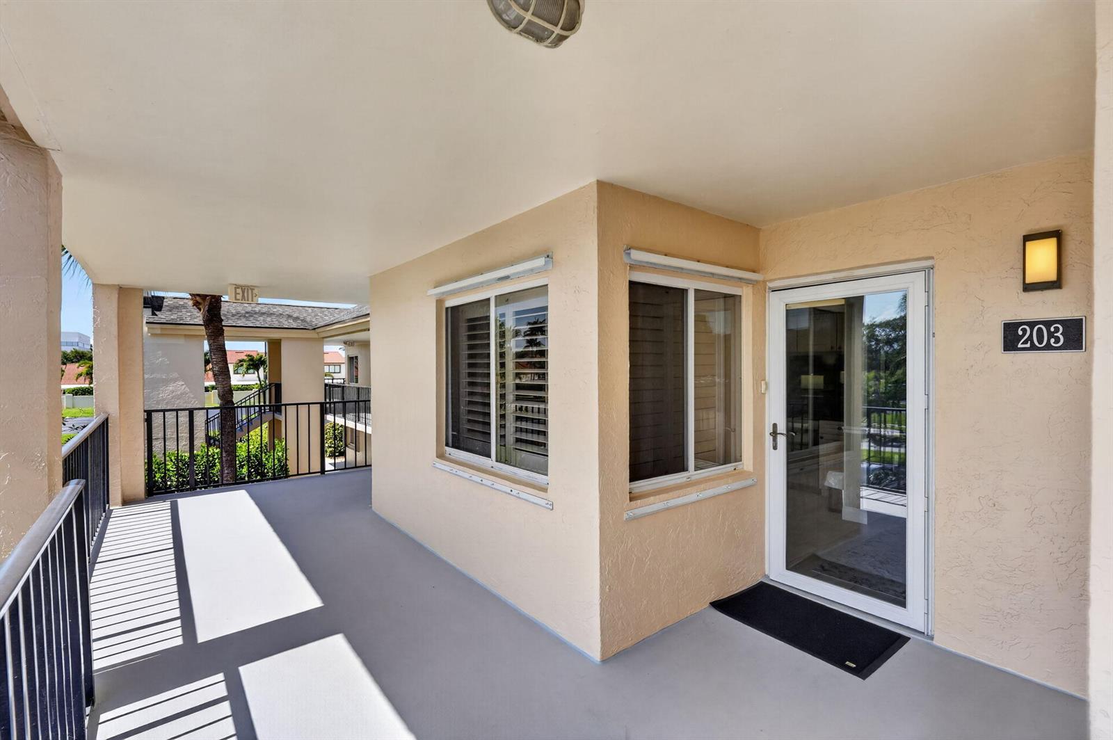 An exterior view of a balcony leading to the entrance of unit 203 — 275 Palm Avenue # D, Jupiter FL 33477, JUPITER, FL