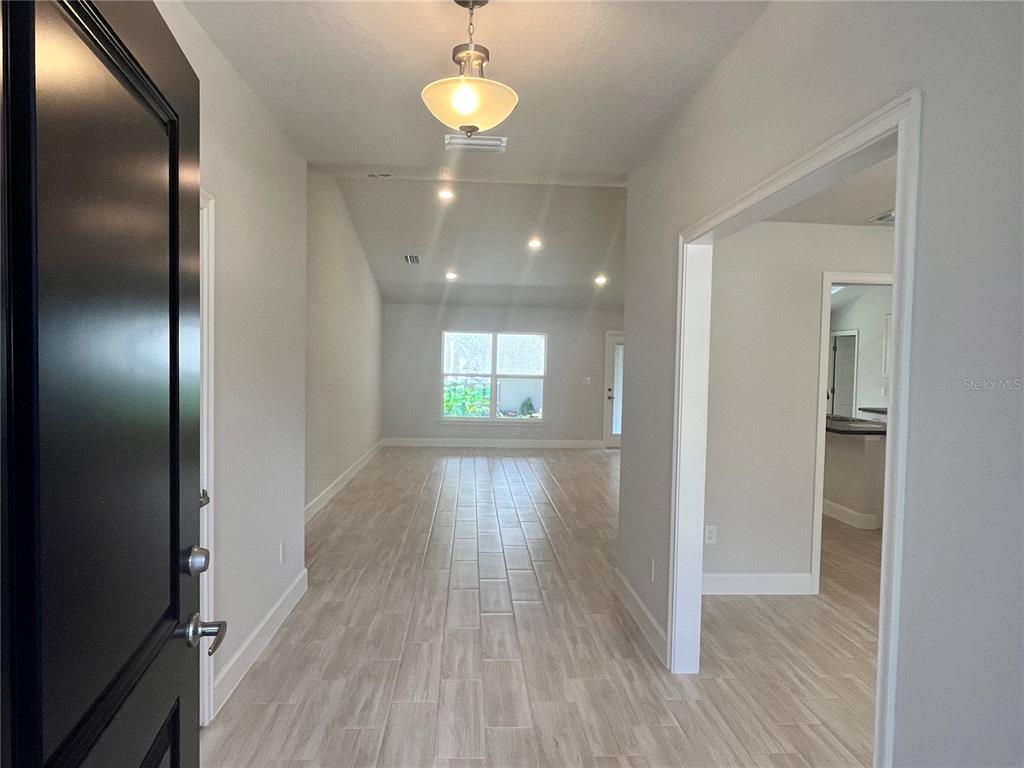 An unfinished interior room features vaulted ceilings and walls covered in newly installed drywall — 15691 SE 97TH AVENUE, SUMMERFIELD, FL
