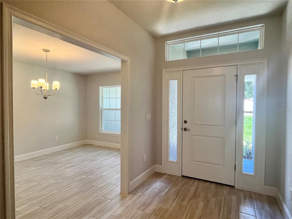 A view from an entryway into a living area with light-colored tile flooring — 15691 SE 97TH AVENUE, SUMMERFIELD, FL