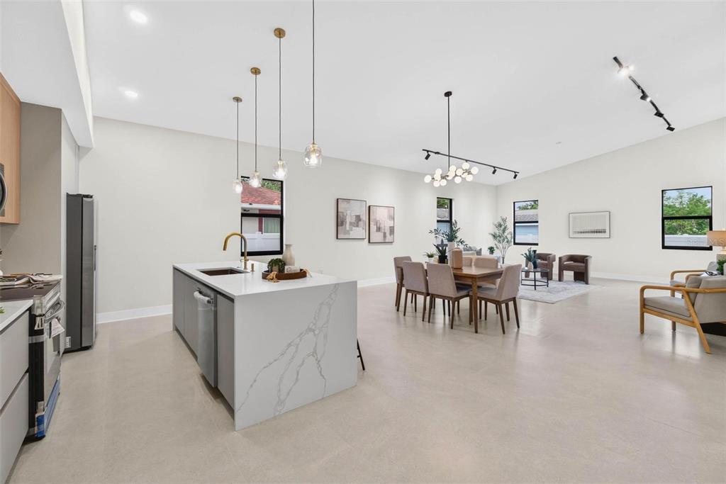 An open-concept kitchen and living area with a marble island, dining table, and neutral flooring — 2227 32ND AVENUE N, ST PETERSBURG, FL