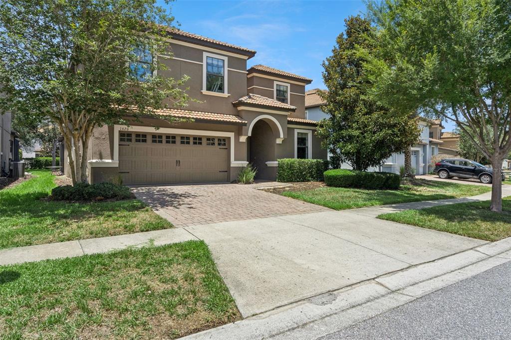 A two-story brown stucco house with a tiled roof and a paved driveway — 1420 MOON VALLEY, DAVENPORT, FL