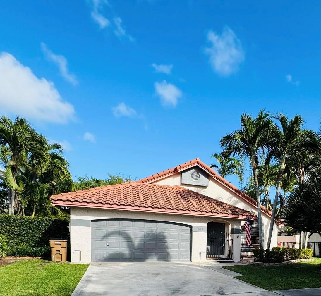 A single-story house with a tiled roof, gray garage door, and palm trees in front — 544 NW 38th Avenue, Deerfield Beach FL 33442, DEERFIELD BEACH, FL