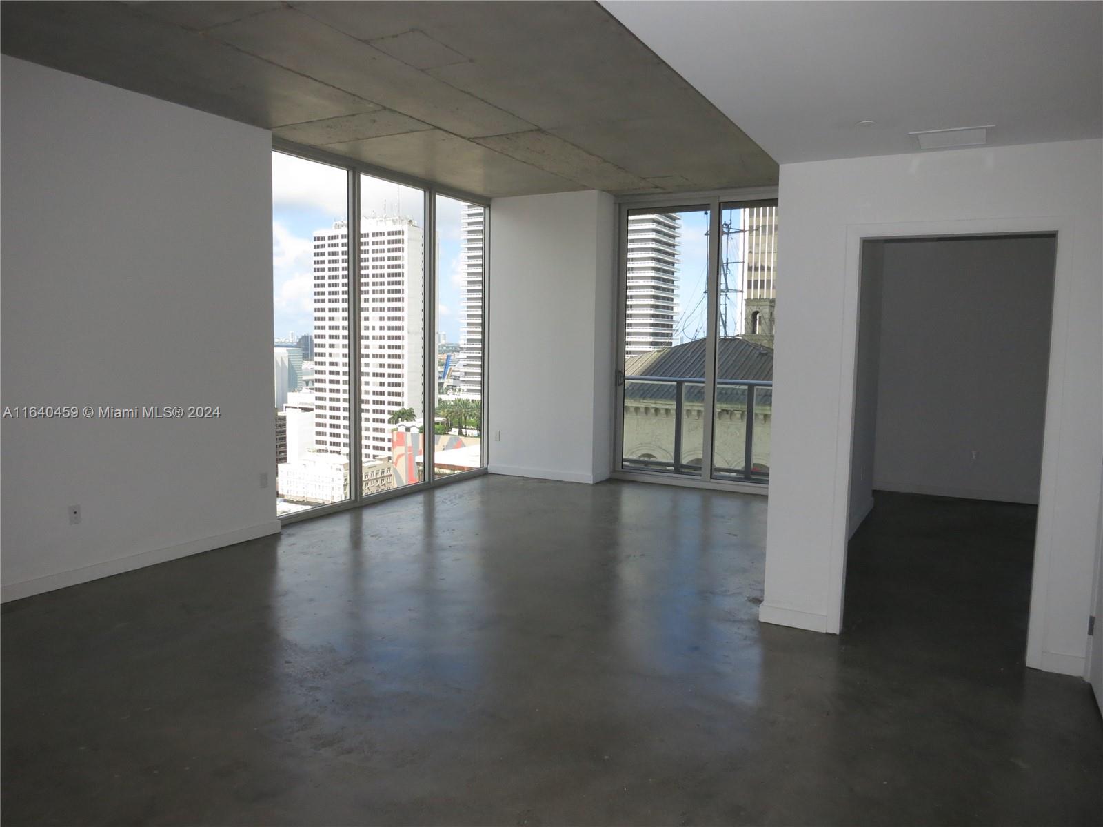 An empty room features polished concrete floors, an exposed concrete ceiling, and floor-to-ceiling windows — 151 SE 1 St # 1902, Miami FL 33131, MIAMI, FL