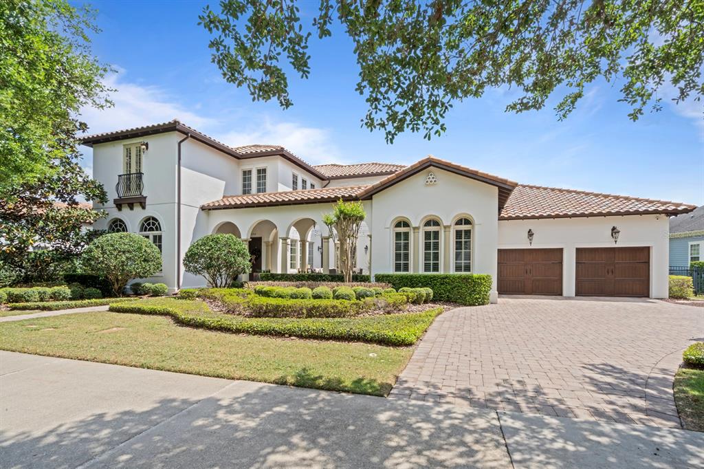 A two-story Mediterranean-style house features a tiled roof, arched entryway, and a brick driveway — 1735 FOSS AVENUE, ORLANDO, FL