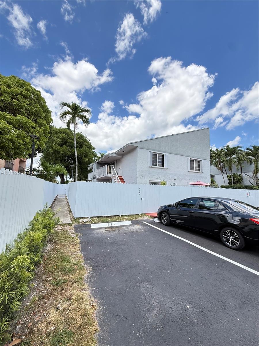 A two-story white building stands behind a white fence with a parking space in front — 8480 SW 156th Pl # 620, Miami FL 33193, MIAMI, FL