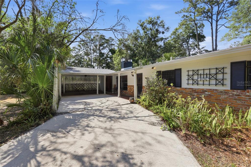 A single-story house with a brick facade, a covered carport, and a concrete driveway — 4130 NW 19TH PLACE, GAINESVILLE, FL