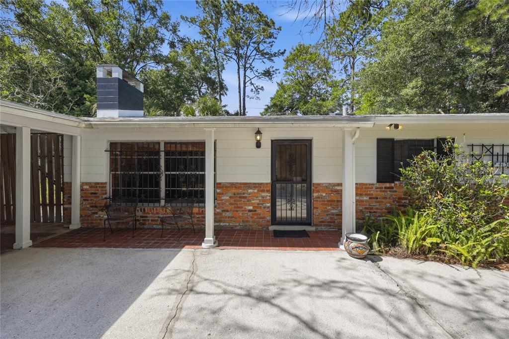 A single-story house exterior features a brick and white siding facade with a covered porch — 4130 NW 19TH PLACE, GAINESVILLE, FL