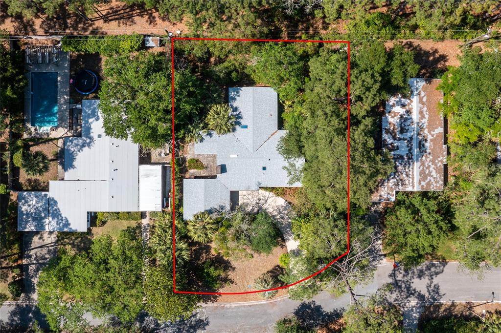 An aerial view shows a house with a gray roof surrounded by trees and landscaping — 4130 NW 19TH PLACE, GAINESVILLE, FL