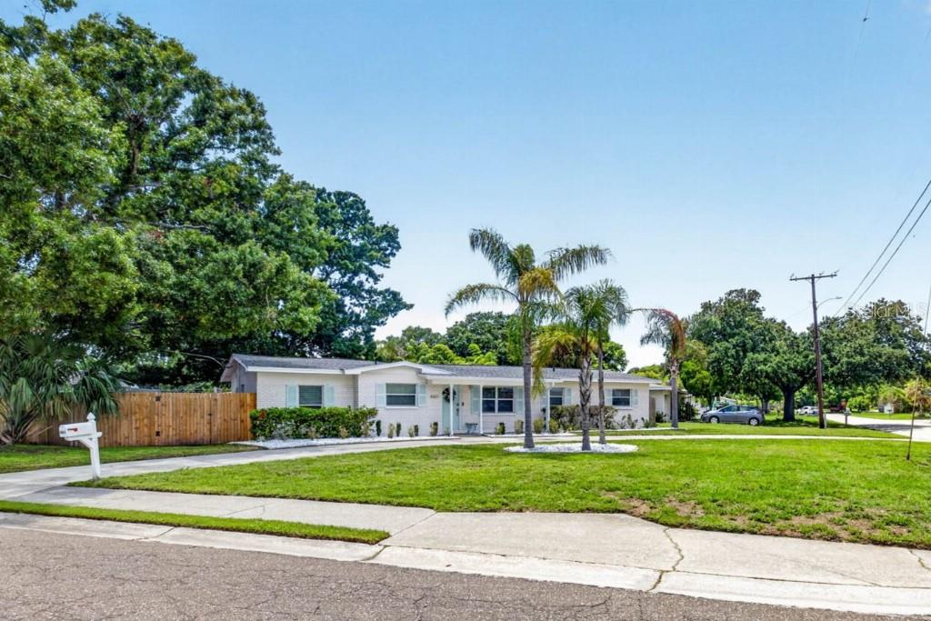 A single-story house with a white exterior, palm trees, and a wooden fence — 4601 S CLARK AVENUE, TAMPA, FL