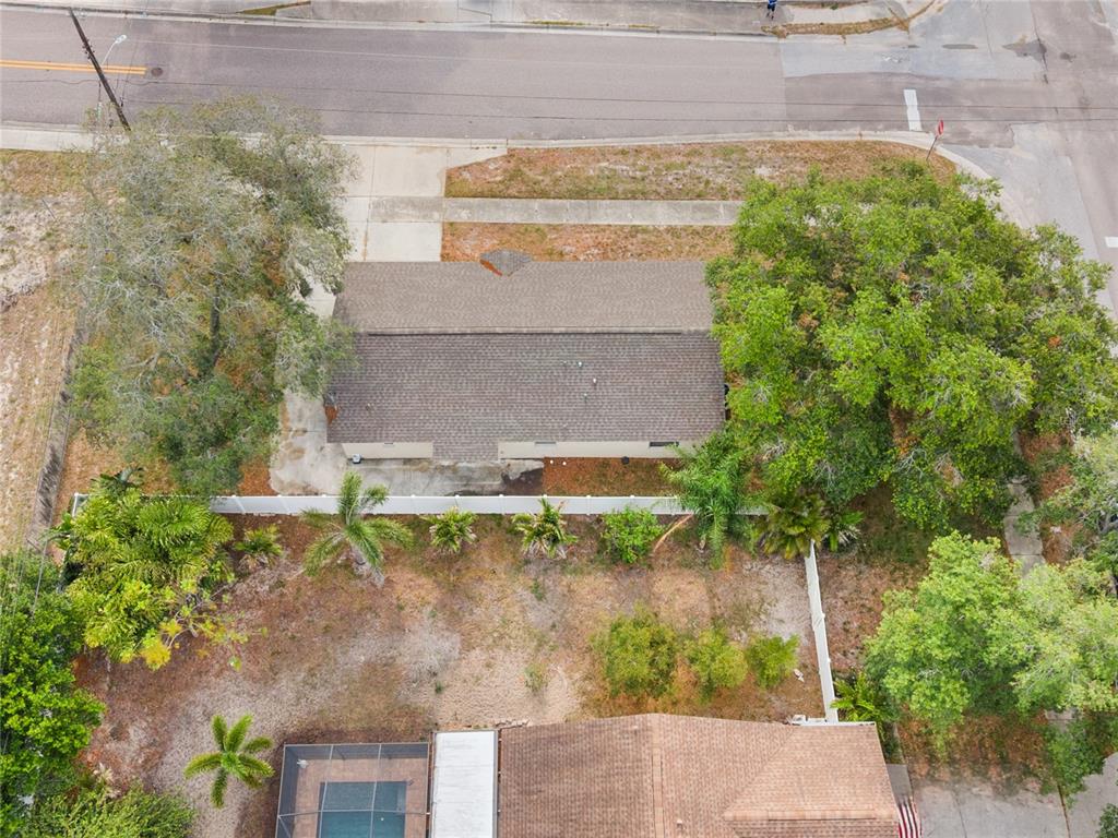 An aerial view shows a house with a brown roof surrounded by trees and landscaping — 1221 E COURT STREET, TARPON SPRINGS, FL