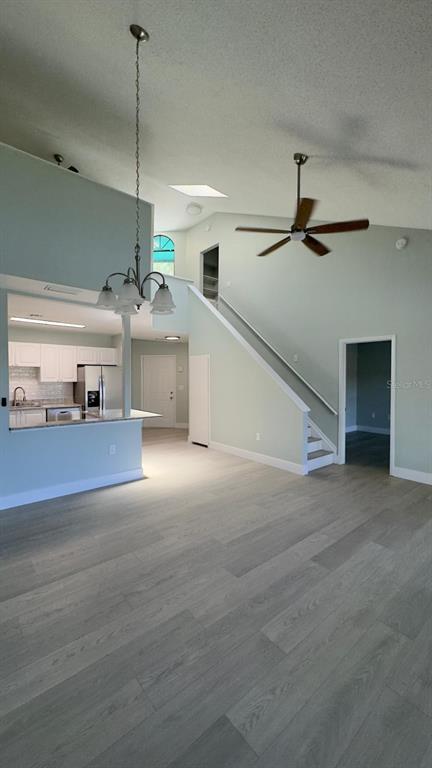 A living area with light wood-look flooring, a ceiling fan, and an open kitchen — 4525 PARK LAKE TERRACE S UNIT 4525, BRADENTON, FL
