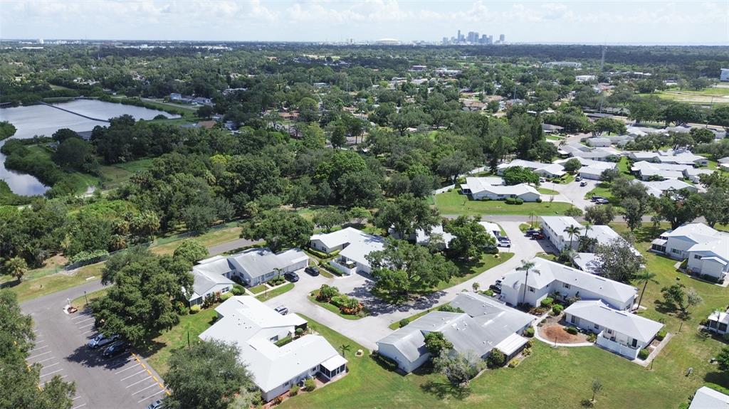 An aerial view of a residential community with white buildings, green trees, and a lake — 3216 39TH STREET UNIT C, ST PETERSBURG, FL