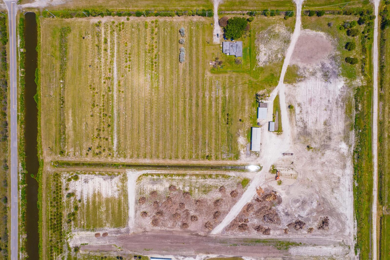 An aerial view shows a rural property with a house, outbuildings, and agricultural fields — 0 Orange Avenue, Fort Pierce FL 34945, FORT PIERCE, FL