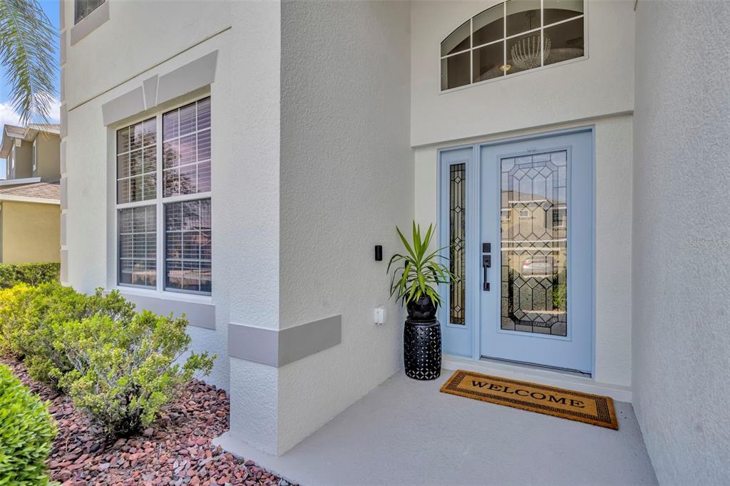 A two-story house with a white stucco exterior, a two-car garage, and a blue door — 2329 NATOMA BLVD, MOUNT DORA, FL
