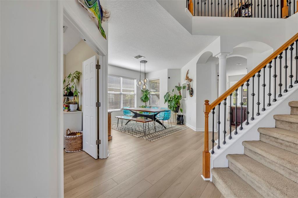 A kitchen with dark wood cabinets, stainless steel appliances, and an island faces a dining area — 2329 NATOMA BLVD, MOUNT DORA, FL